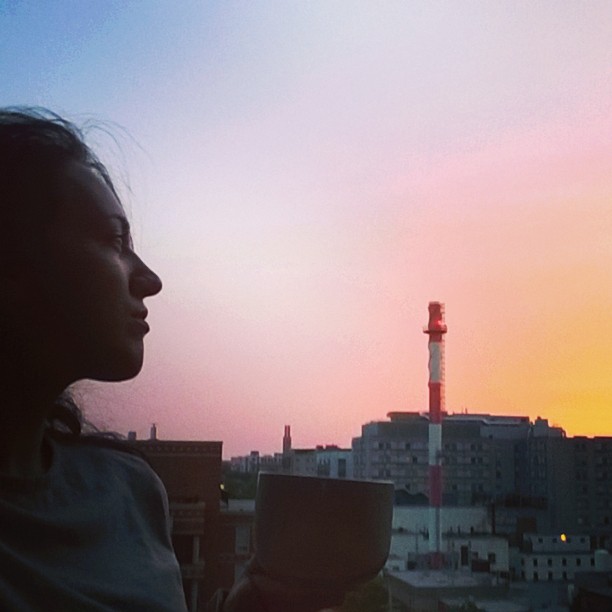 Tea and yoga on the balcony under a setting pastel sky